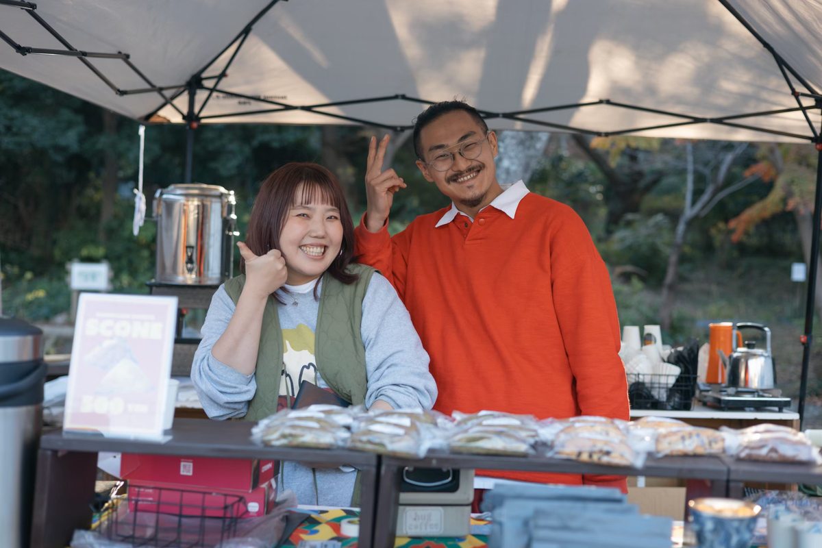 フードのブースでポーズをとる二人の出店者