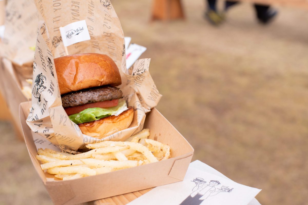 紙のトレーに盛り付けられたハンバーガーとフライドポテト