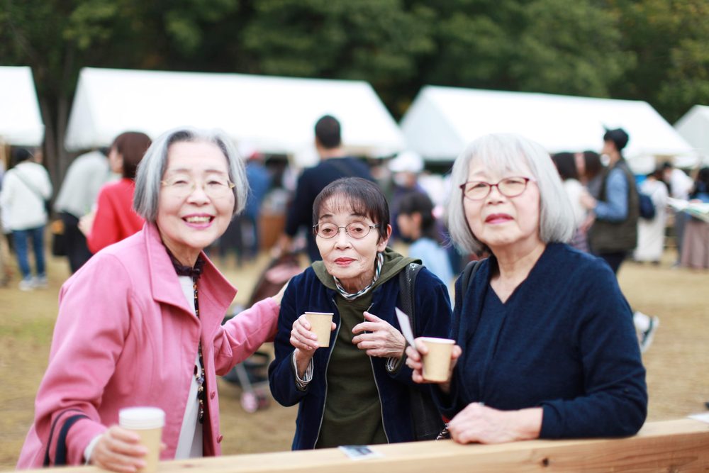 コーヒーを手に集まる三人の来場者